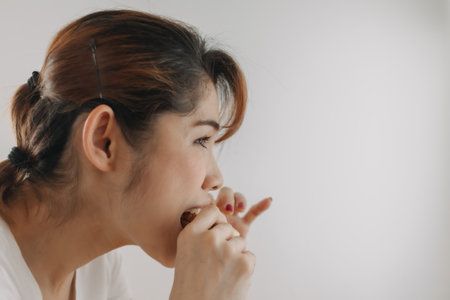 Close up face of Asian woman bite a piece of bread on white background.の写真素材