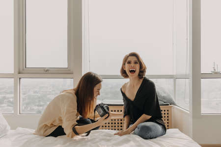 Cool looking Asian women friends having photoshoot in their apartment.の写真素材
