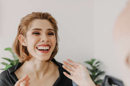 Asian woman model is being applied makeup by makeup artist in the studio.