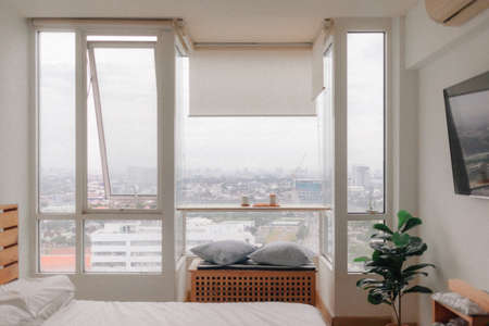 Real life cozy minimal loft bedroom in small apartment with city view.の写真素材