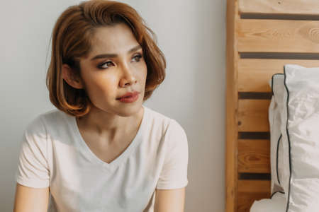 Cool looks of an Asian woman in a t-shirt and jeans relax in her apartment room.