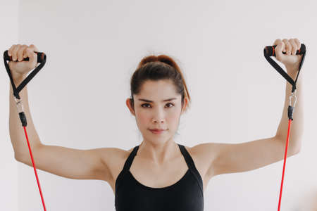Asian woman do Resistance Band Upper Chest Press workout in her bedroom.の写真素材