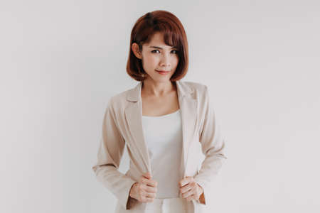 Confident Asian working woman in beige blazer isolated on white background.の写真素材