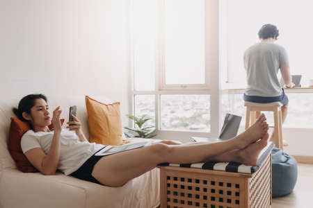 Asian couple living work and rest in the same room apartment.の写真素材