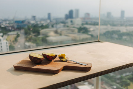 Sweet potato cut into half serve with teaspoon on wooden board.の写真素材