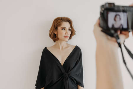 Asian woman photographer is taking a photo of her woman fashion model.
