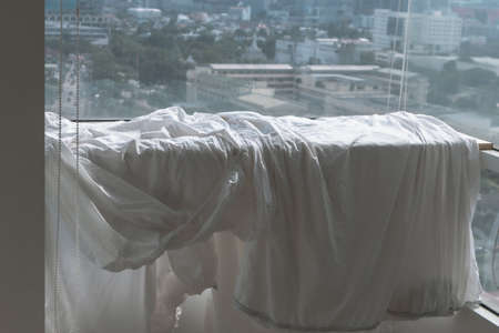 White Bed sheets and duvet clothes hanging on the balcony to dry in apartment.