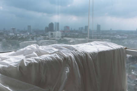 White Bed sheets and duvet clothes hanging on the balcony to dry in apartment.