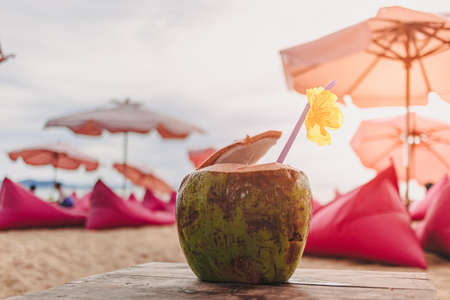 Coconut decorated with yellow flower at the beach cafe in summer.