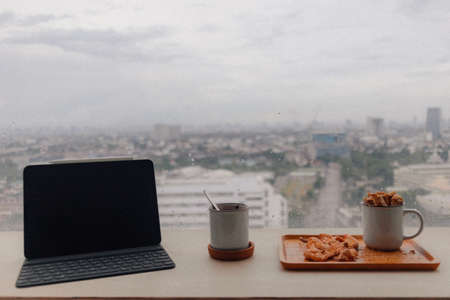Tablet and snack in apartment room in concept of work from home.の写真素材
