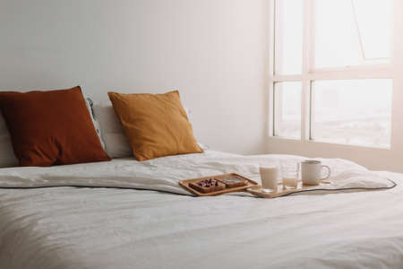 Breakfast set of breads and jam with milk and coffee served on white bed.の写真素材