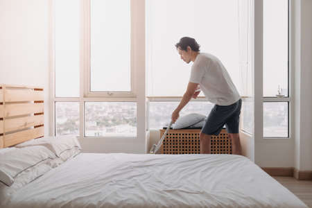 Asian man clean his bedroom apartment with mop.の写真素材