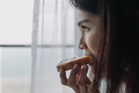 Asian woman eat bread with sweetened condensed milk as easy breakfast.の写真素材