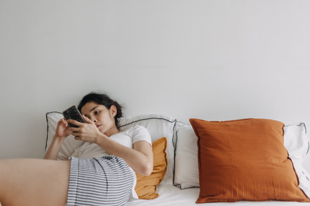 Bored Asian woman use smartphone social media for killing time in apartment.