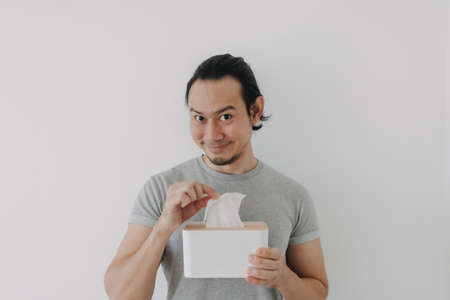 Funny smile face of Asian man holding tissue in concept of self satisfied.の写真素材