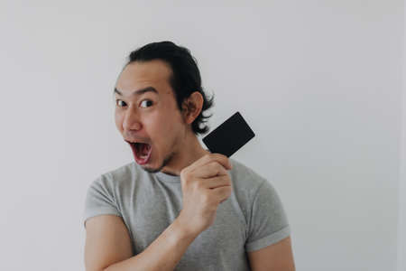 Excited face of Asian man showing black mockup card in his hand.の写真素材