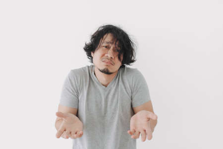 Helpless and hopeless face of Asian man can not solve problem on grey t-shirt.の写真素材