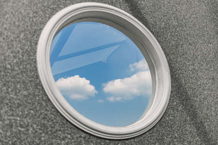 Small circle windows with blue sky view on grey wall.の写真素材