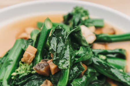 Kale with Oyster Sauce stir-fried asian dish served on wooden table.の写真素材