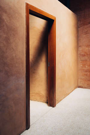 Interior door design of neat cob house with concept of light and earth.