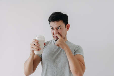 Asian man drink bad taste of protein chicken shake for health isolated on white.の写真素材