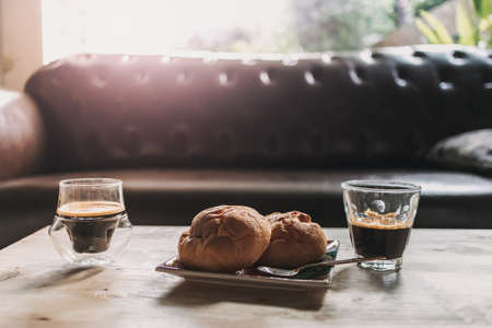 Morning break espresso coffee with desserts in calm living room.の写真素材