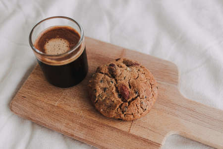 Hot espresso coffee served with homemade cookies on wooden board.の写真素材