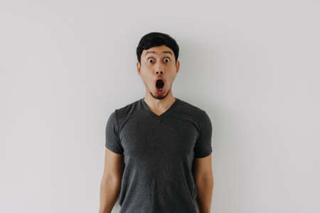 Funny amazing shocked surprised asian man face advertise isolated on whiteの写真素材