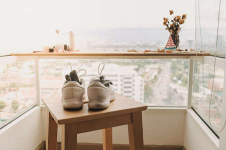 Running shoes being dried on wooden chair by the windows after workout.の写真素材