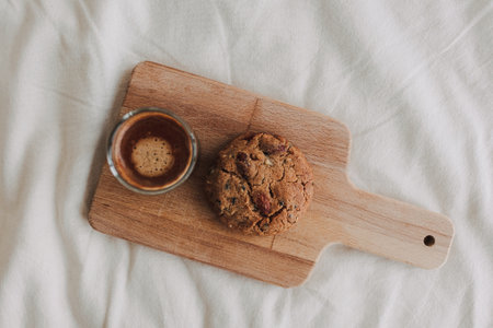 Hot espresso coffee served with homemade cookies on wooden board.の写真素材