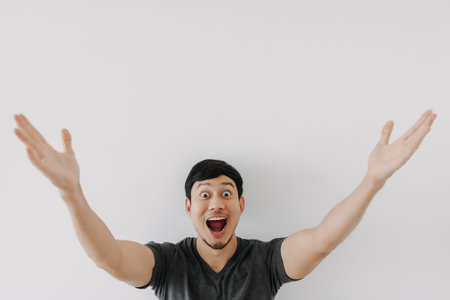 Wow surprise shock face Asian man in black t-shirt isolated on white background.の写真素材