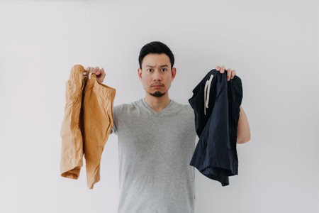Asian man choosing a new short pants to wear isolated on white.の写真素材