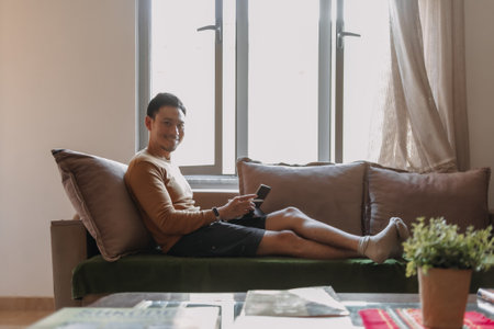 Asian man working with tablet and relax on the sofa. Concept work and travel.の写真素材