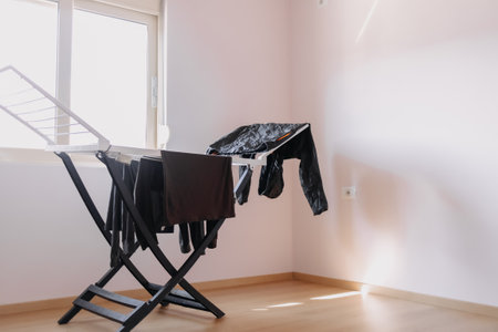 Asian man hanging clothe to dry by the sun from the windows. Home routine.