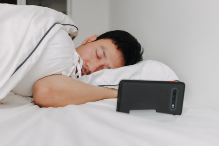 Asian man sleep overnight while on video call with his girlfriend. Distance love.の写真素材