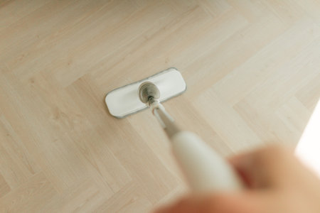 White mop cleaning dust on the wooden floor of the apartment.の写真素材