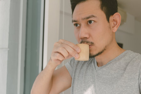 Close up of Asian man having a shot of coffee or tea in the morning.