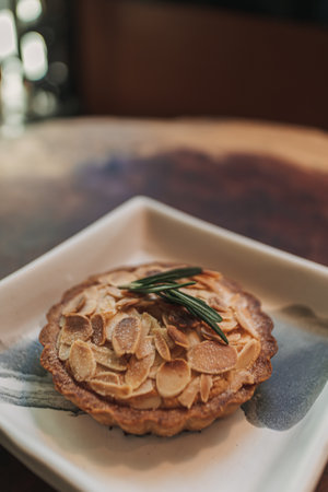 Closeup of small tart almond slice served on wooden table in the cafe.の写真素材