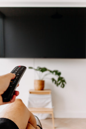 Hand holding remote point at the tv. Concept of watching tv,の写真素材