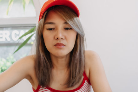 Portrait of cute asian girl in red wearing red hat.の写真素材