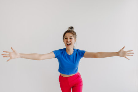 Happy and cheerful asian woman with wide arms open isolated on white.の写真素材