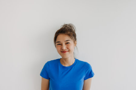 Close up of happy asian woman in blue t-shirt isolated on white.の写真素材