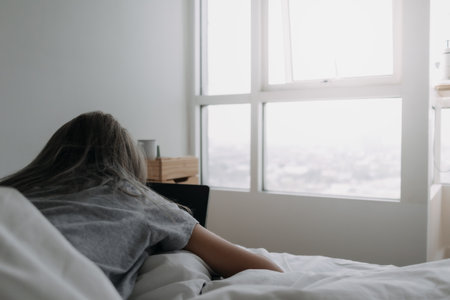 Asian woman sleep on tablet computer on bed in the morning. Early online work.の写真素材