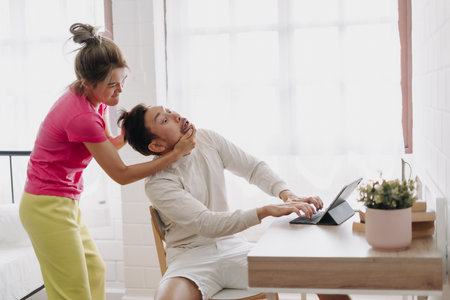 Funny argument asian couple. Wife force husband to stop his work.の写真素材