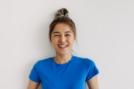 Close up of happy asian woman in blue t-shirt isolated on white.の写真素材
