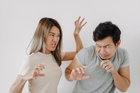 Domestic violence of asian wife hitting husband isolated on white.の写真素材