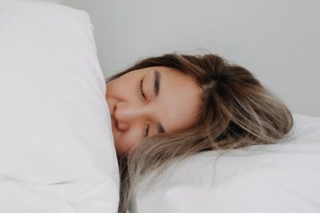 Happy asian woman still sleeping peacefully in the morning.の写真素材