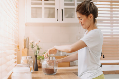 Asian woman rearrange equipments items and cleaning the kitchen.の写真素材