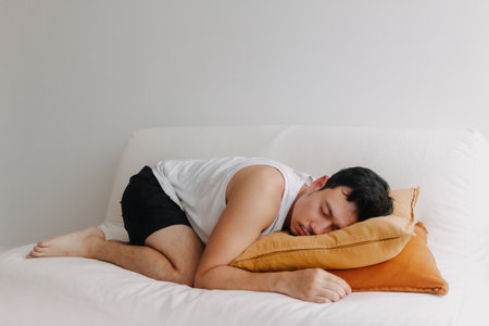 Asian man resting on the sofa in the afternoon as he tired.の写真素材