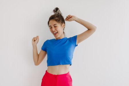 Portrait of happy cheerful asian woman in colorful clothes isolated on white.